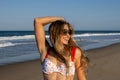 Woman in a bikini standing on a beach with ocean waves in the background